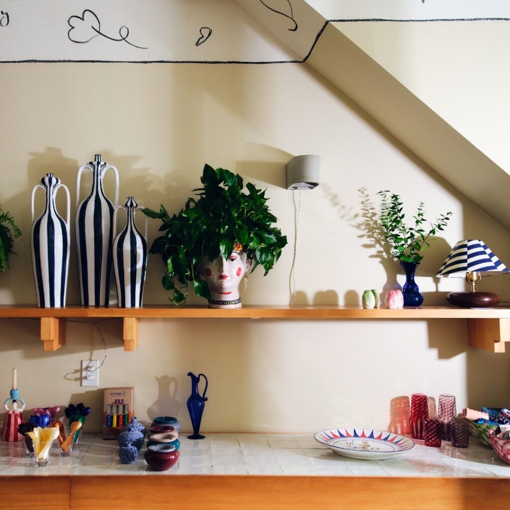 The inside of Porta design shop in Boerum Hill with a kitchen counter and shelf above the counter with various household objects on them.