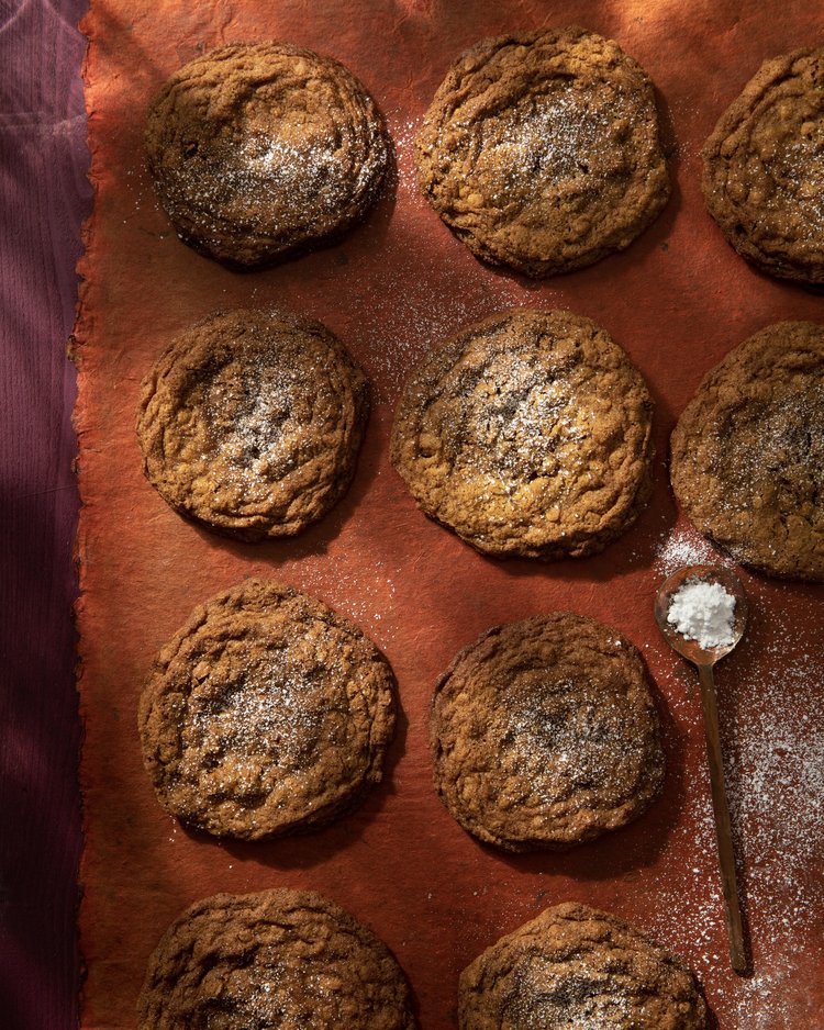 An aerial shot of six brown cookies. They are Gluten-Free 7 Spice Oatmeal and Golden Raisin Cookies.