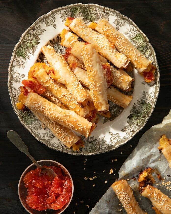 Cheesy Pepper Jelly Cigars sits atop a green and white plate.