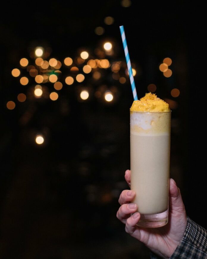 A white creamy, winter cocktail in a slim glass.