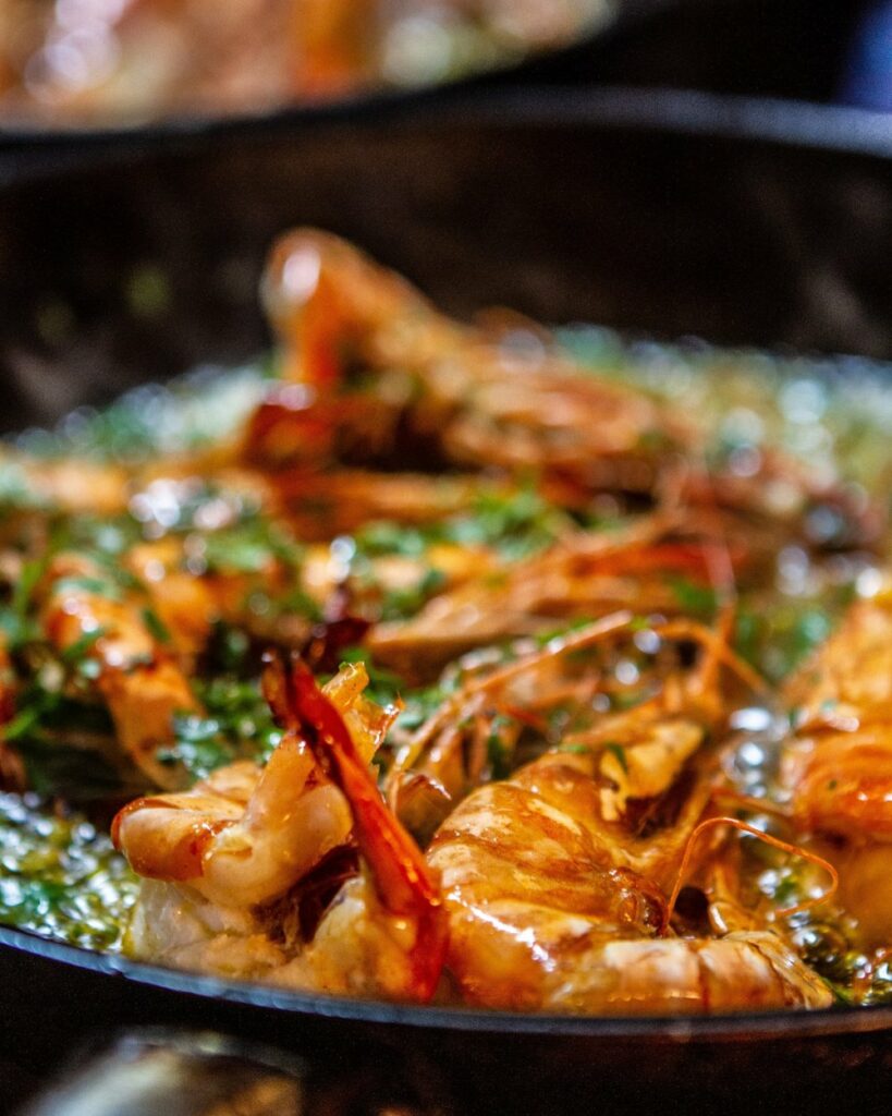 Gambas al Ajillo, aka Garlic Shrimp, in a deep black dish.