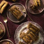 Three plates holds slices of Apple Bourbon Quinoa Cake on a burgundy table.