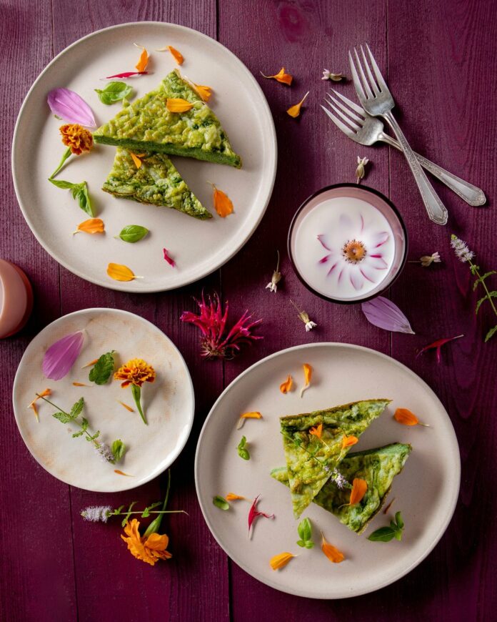 Green+Eggs+recipe+TABLE+Magazine+Petrilla Green eggs adorned with flowers sit on three different plates.