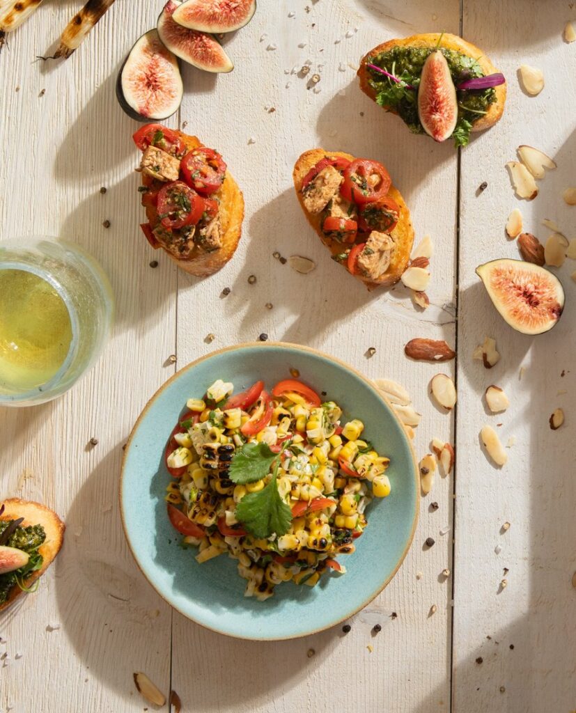 A grilled sweet corn salad lays on a blue bowl.