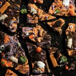 Halloween Candy Bark in various colors with halloween cnady baked in on top.