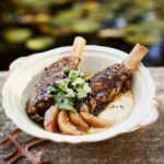 Two lamb shanks sit in an off-white bowl.