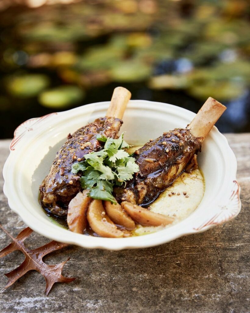 Two lamb shanks sit in an off-white bowl.