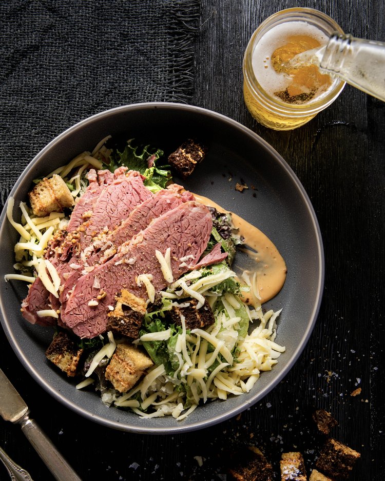 Reuben salad with sliced meat on top and a drizzle of thousand island dressing.