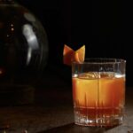 Satan's Whiskers cocktail in a coupe glass with an orange peel garnish.