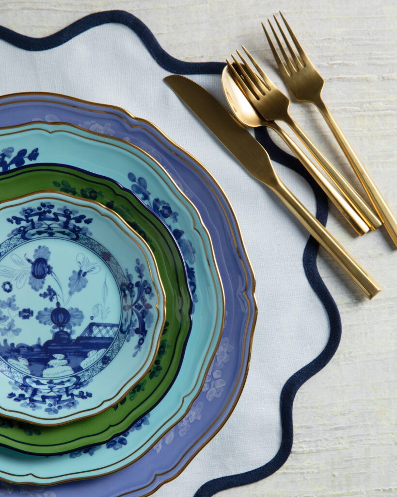 A photo of flat-lay of plates with gold-tone fork, knife, and spoon illustrating a color design article.