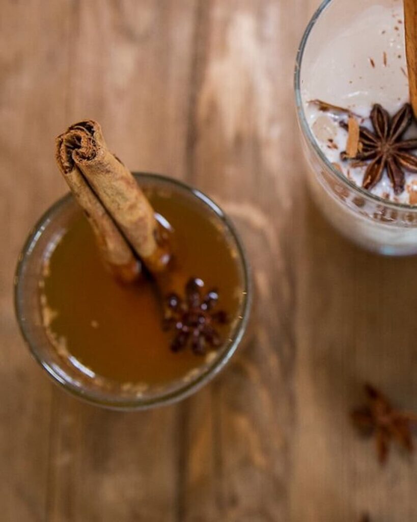 Haitian Ginger Tea with a cinnamon stick served in a glass