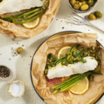 A plate of fish in papillote with an olive and herb relish.