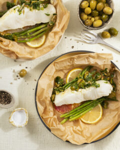 A plate of fish in papillote with an olive and herb relish.