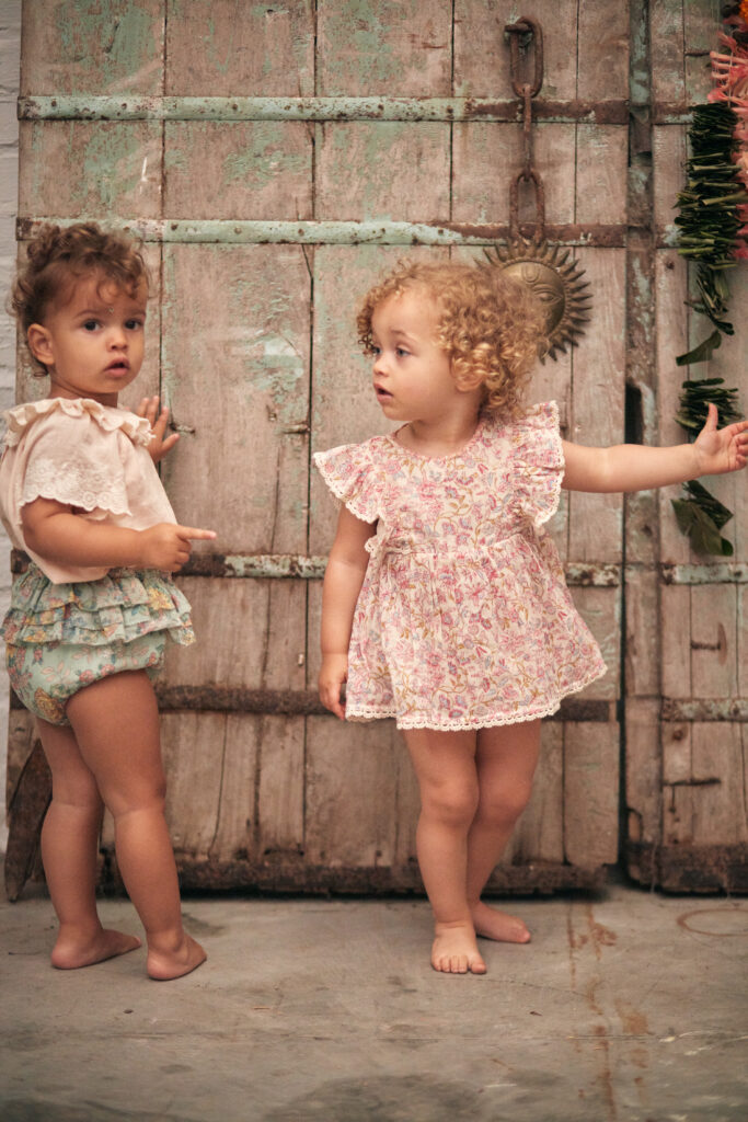 A photo of two children modeling clothing by designer Louise Misha for a color design article. 