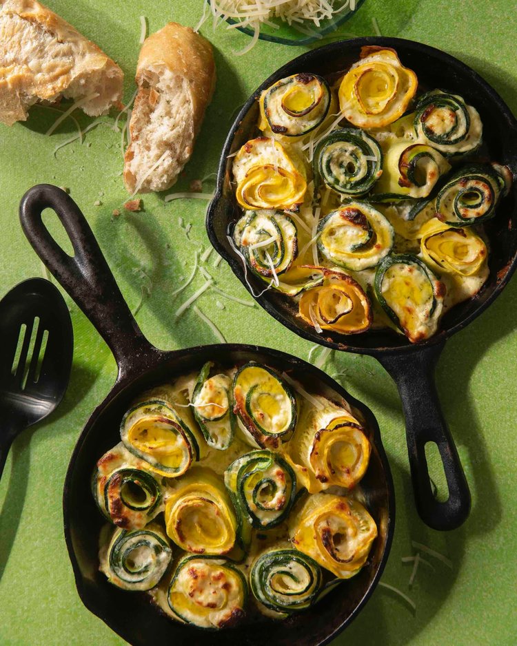 Zucchini and yellow summer squash fill two cast iron pans.