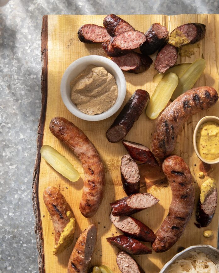 a wooden board with a variety of sausages and mustards from a Pittsburgh eatery