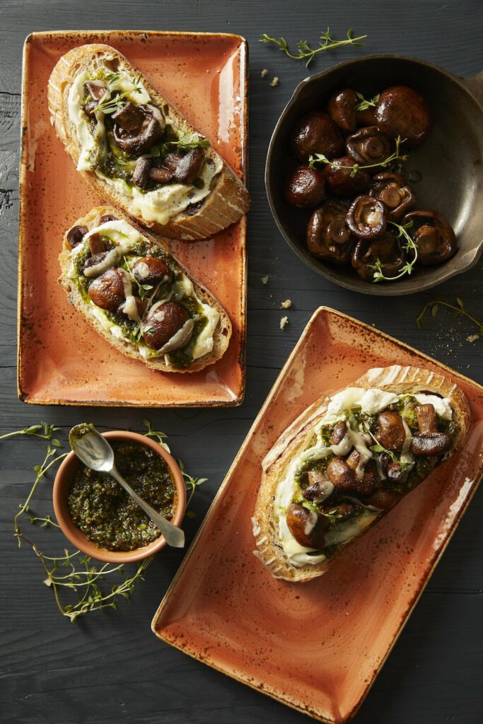 Buttered Mushroom Tartine on two separate plates with mushrooms in one plate and a dip sauce in another