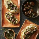 Buttered Mushroom Tartine on two separate plates with mushrooms in one plate and a dip sauce in another