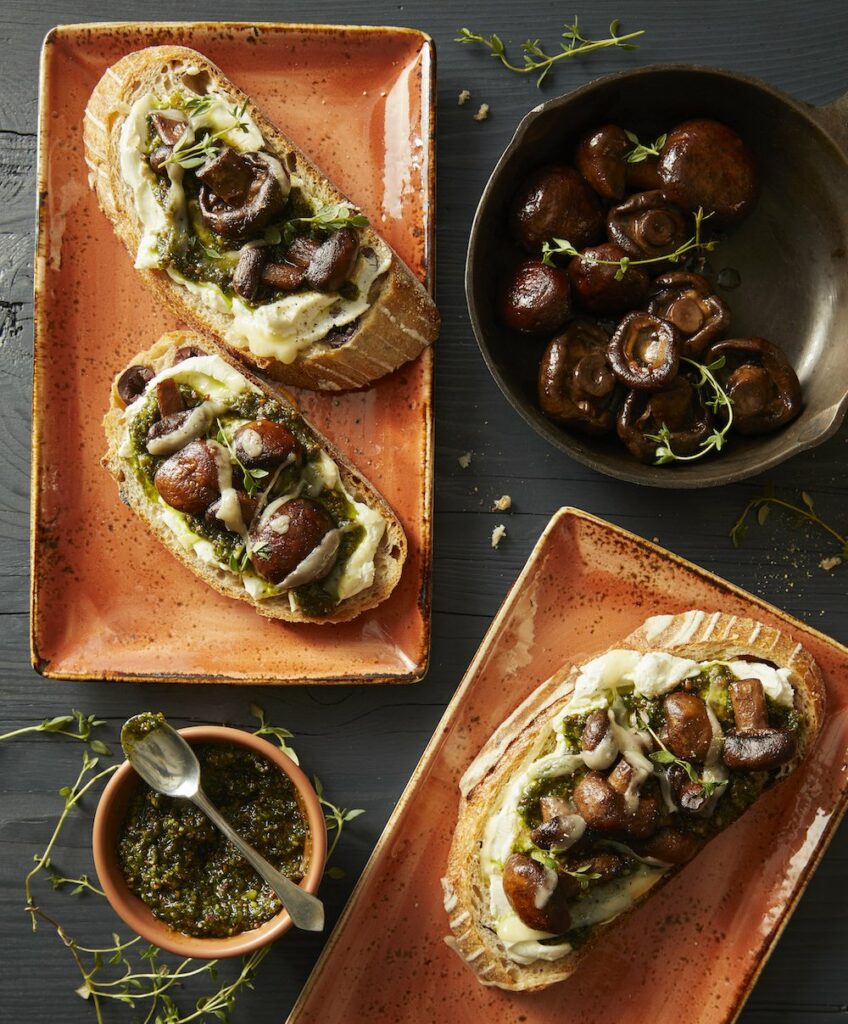 Buttered Mushroom Tartine on two separate plates with mushrooms in one plate and a dip sauce in another