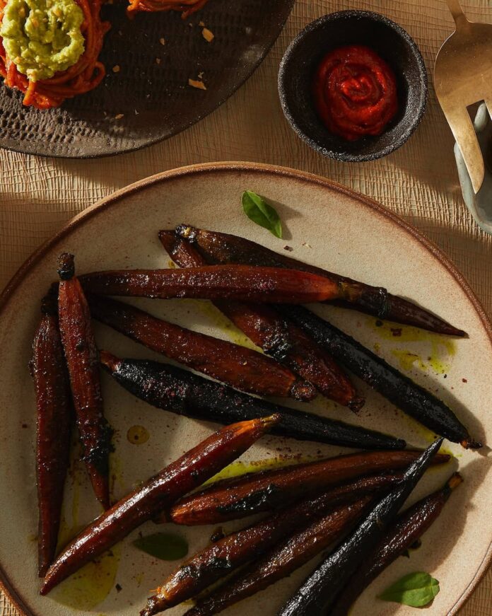 Honey and Ghee Roasted Carrots served on a ceramic plate with a sauce on the side