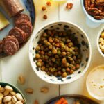 Green Coconut Curry Chickpeas served in a bowl with several side snacks surrounding it.