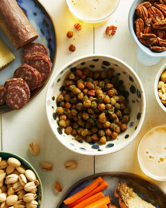 Green Coconut Curry Chickpeas served in a bowl with several side snacks surrounding it.