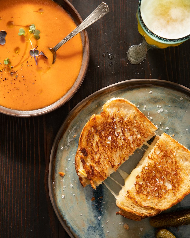 Sliced cheese bread with a bowl of tomato soup