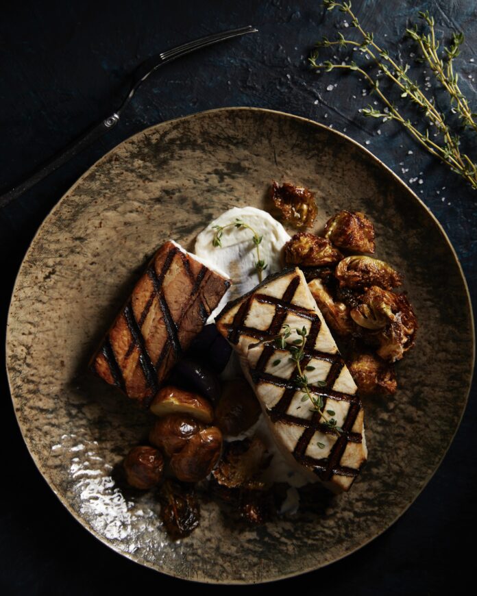 2 pieces of white fish with grilling marks, Brussels sprouts, and mushrooms on a plate. allergen-free