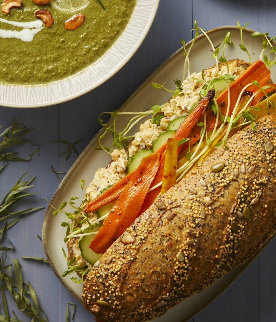 Roasted Carrot and Chickpea Sandwich on a plate along with a plate of side dish