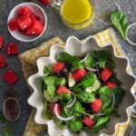 Watermelon salad in a spiral bowl, which is placed on a napkin, Pieces of watermelon in a smaller bowl