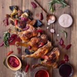 Duck legs arranged in a line with various sauces