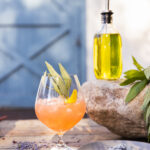 Gin cocktail garnished with fresh herbs and served outdoors