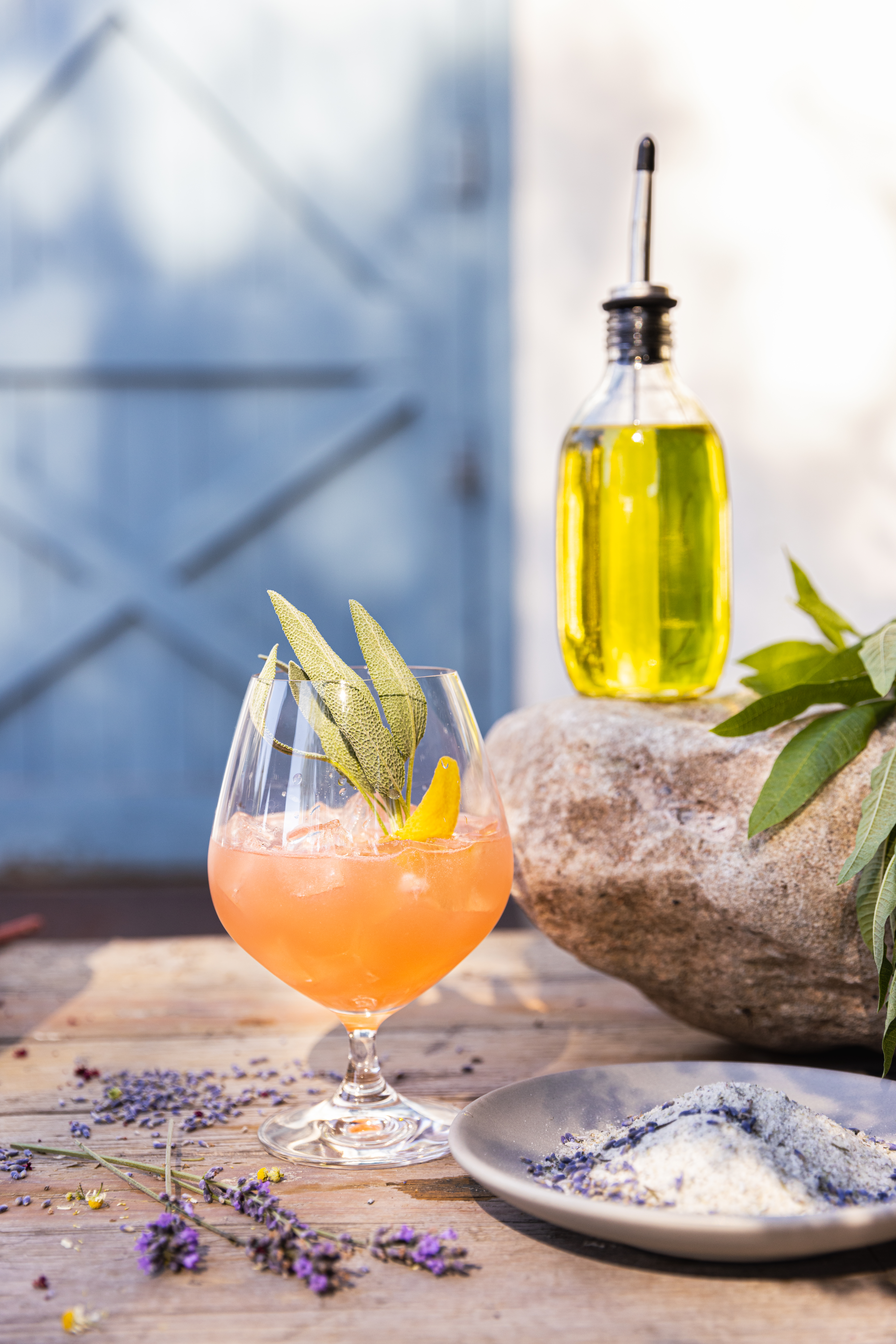 Gin cocktail garnished with fresh herbs and served outdoors