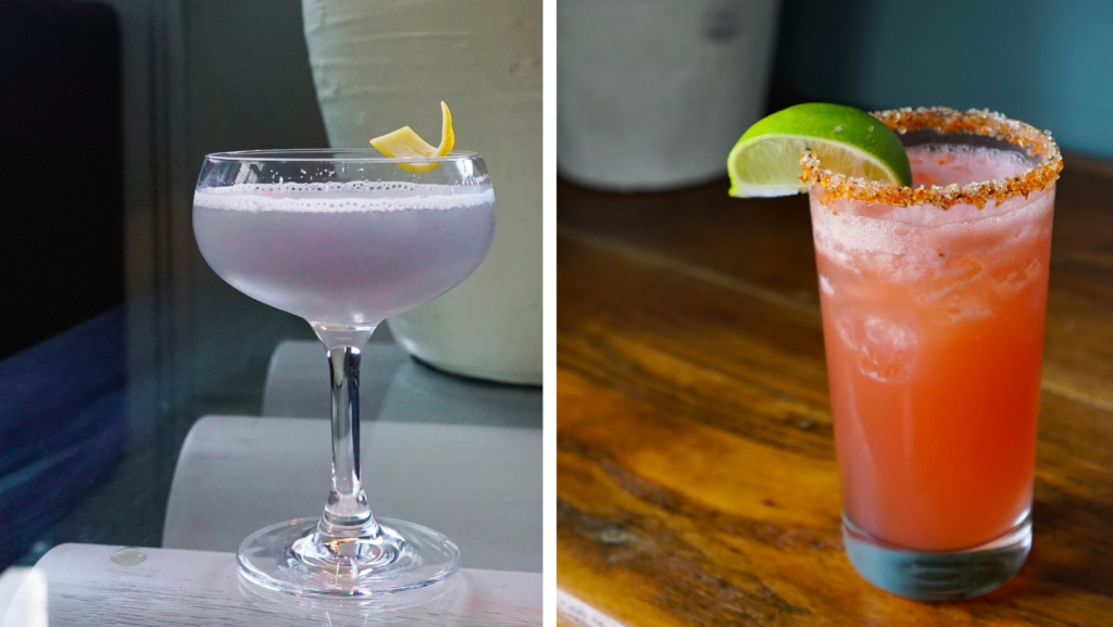 a lavender cocktail with a lemon peel garnish on a glass table and a margarita in a tall glass with a lime wedge and a tan rimmed glass on a wooden table