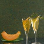 A delightful and refreshing twist on the classic Cantaloupe 75 cocktail, featuring the essence of ripe cantaloupe, sparkling wine, gin, and a hint of zesty citrus, served in an elegant glass.