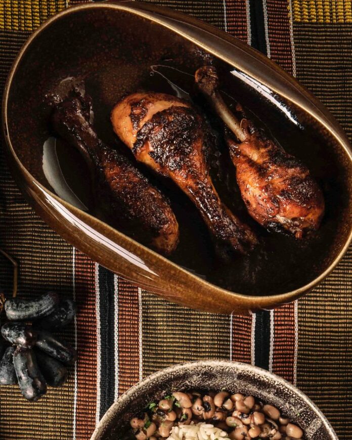 A mouthwatering dish of perfectly grilled jerk chicken marinated in a flavorful blend of Caribbean spices, creating a delicious combination of smoky, spicy, and tangy flavors.