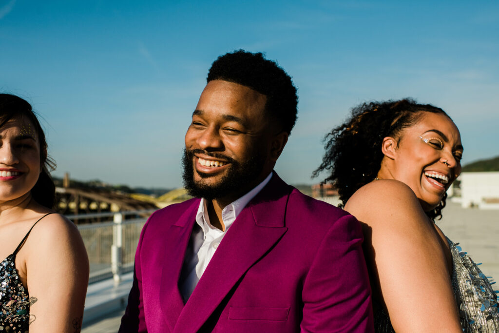 3 people smiling on a rooftop. Riverlife's 2023 Party at the Pier