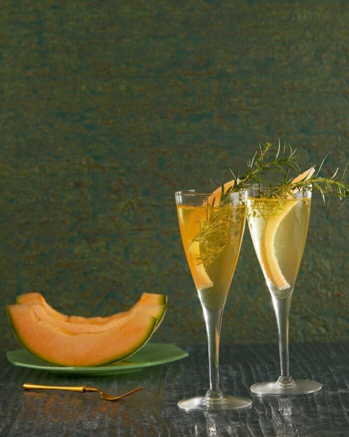 A delightful and refreshing twist on the classic Cantaloupe 75 cocktail, featuring the essence of ripe cantaloupe, sparkling wine, gin, and a hint of zesty citrus, served in an elegant glass.