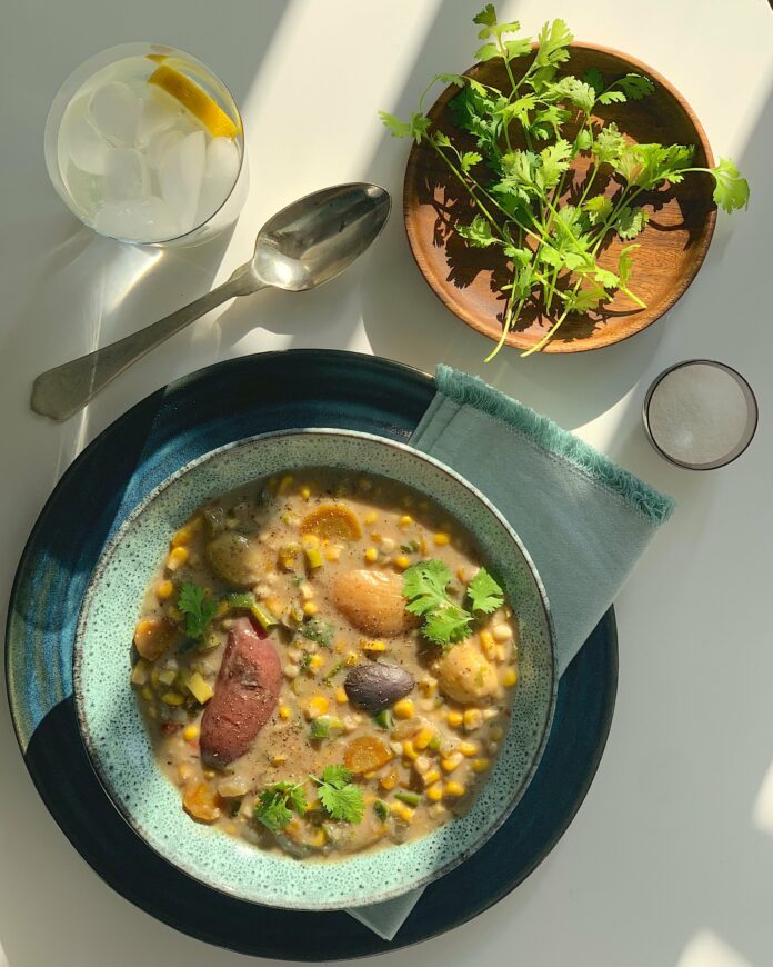 An aerial view of corn chower in a light blue-green bowl. corn chowder recipe