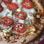 A delectable pizza topped with ripe tomatoes and creamy feta cheese. The perfect combination of flavors for pizza lovers to enjoy. Tomato and Feta Pizza Recipe