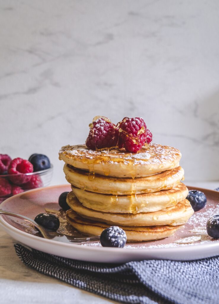 a stack of pancakes on a plate with berries