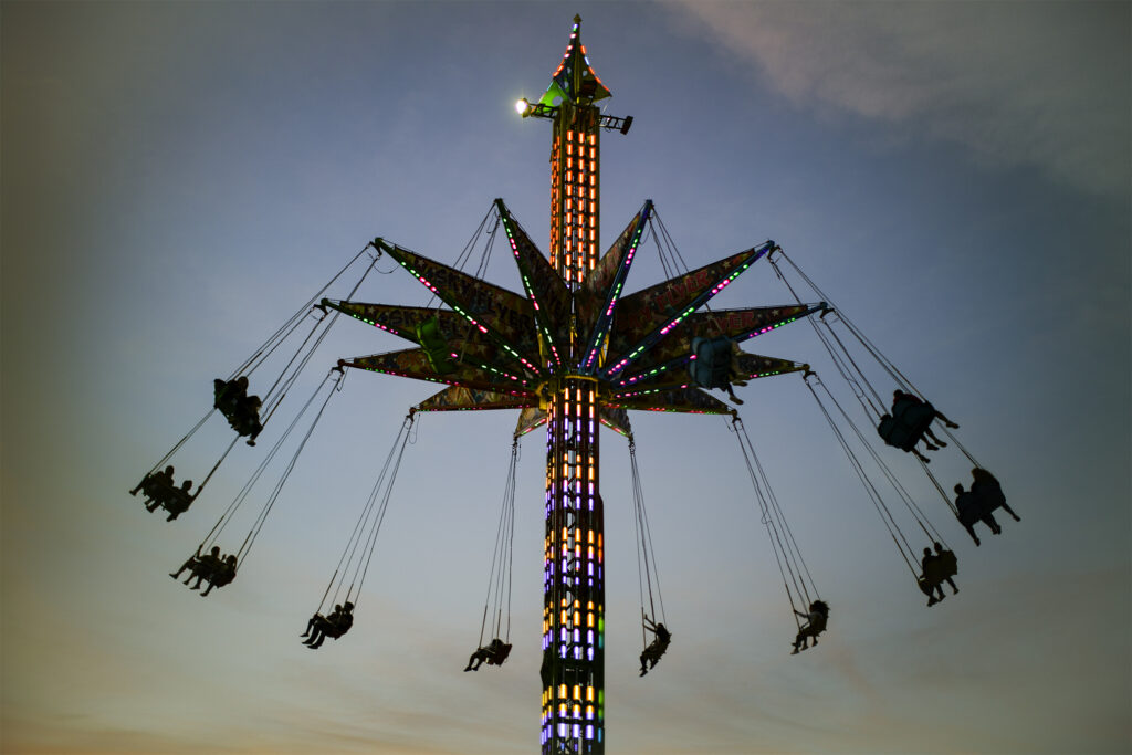 An amusement park ride sits high in a blue sky