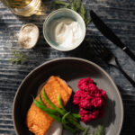 Seared Salmon with Borscht Risotto and Horseradish Crème Fraîche sits in a grey plate with high edges. Seared Salmon recipe