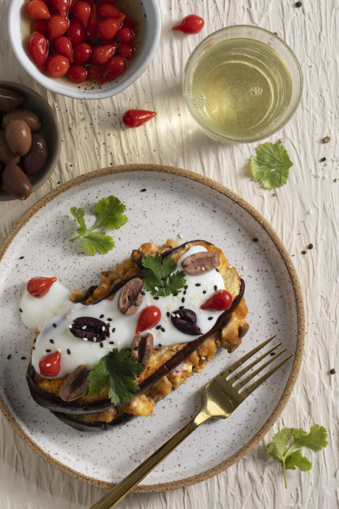 Low Carb Eggplant Napoleon two slices of eggplant with hummus in between and a yogurt sauce with cherry peppers, Kalamata olives, and sesame seeds on top. Low Carb Eggplant Napoleon