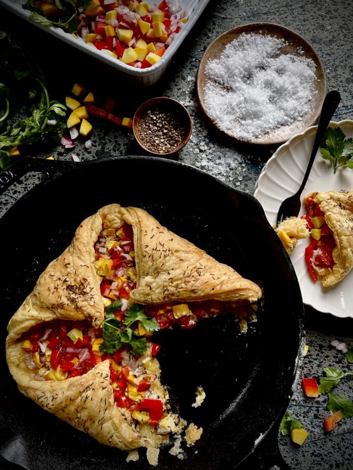 Summer Veggie en Croute A summer veggie en croute, puff pastry filled with chopped vegetables in a cast iron skillet