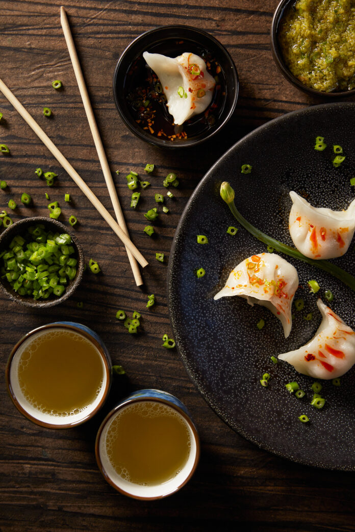 Ginger and Scallion Sauce A spread of dumplings and Ginger and Scallion Sauce on a wooden table. Chopsticks sit to the left of the dumplings. Ginger and Scallion Sauce Recipe