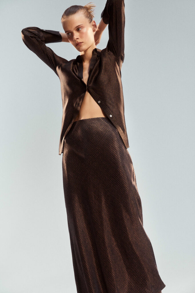 a woman wearing a matching top and long skirt in A classic houndstooth pattern rendered in black and camel. stealth luxury