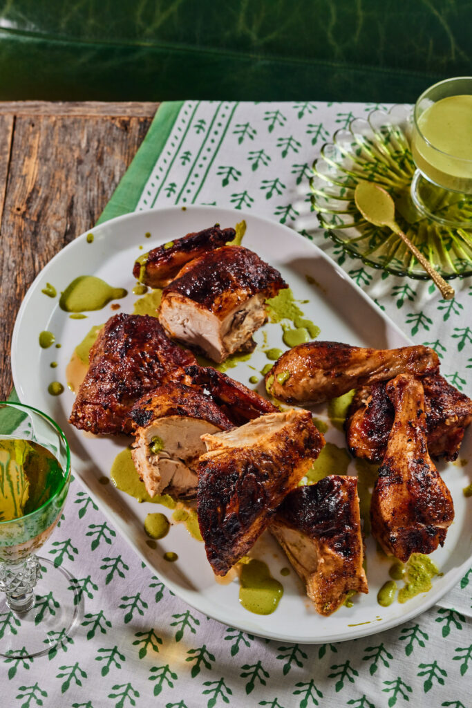 An aerial shot of crispy Roast Chicken with Spicy Green Sauce sitting on a white serving tray.