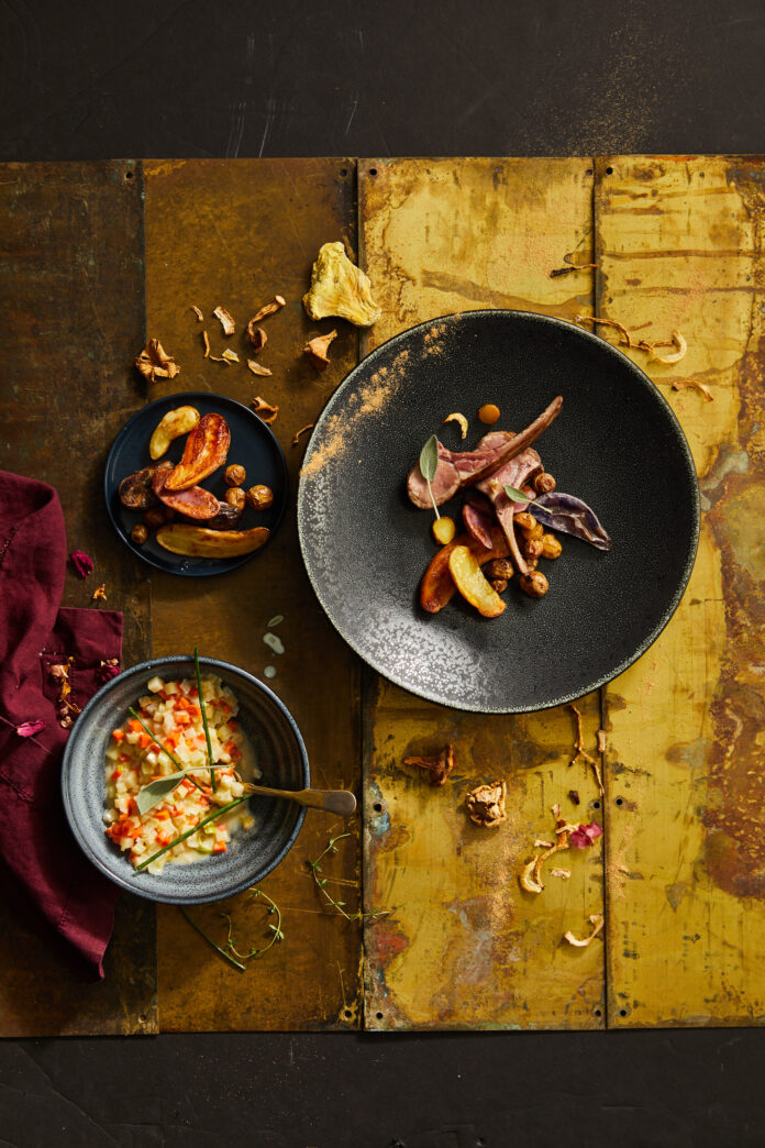 An aerial shot of a round bowl with Wild Mushroom-Crusted Wild Boar. On the side sits Root Vegetable Porridge. Wild Boar Recipe