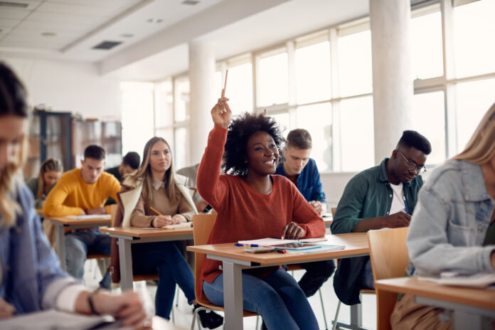 Happy Black student raising her hand to ask a question during lecture in the classroom. pittsburgh school culture